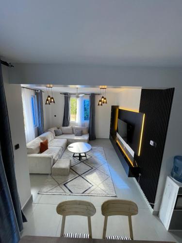 a living room with a couch and a tv at Deanway homes,2bedroom Apartment Vale Residence Nyali in Mombasa