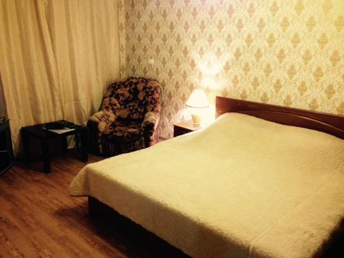 ペルミにあるApartment Kim 83のベッドルーム1室(ベッド1台、椅子、ランプ付)