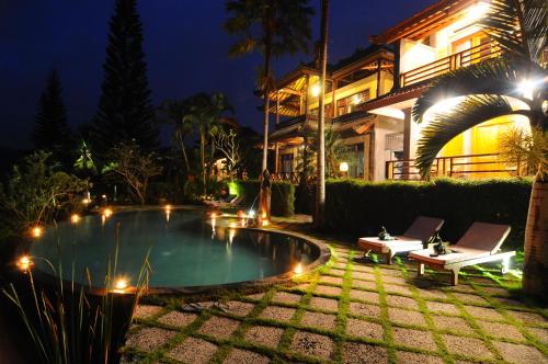 a patio area with a pool, chairs, and a fire hydrant at Villa Karma Loka in Sidemen