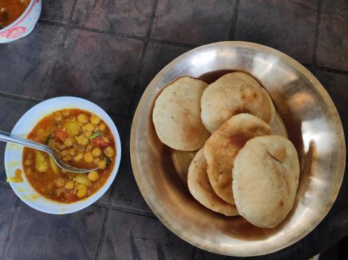 a metal bowl of food with biscuits and a bowl of soup at Kanchan Kunja Homestay in Rishop