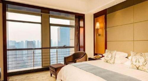 a hotel room with a bed and a large window at Gaosu New Century Hotel International Anhui in Hefei