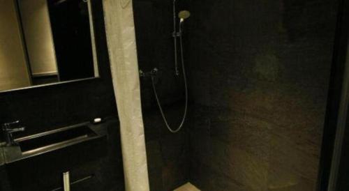 a shower in a bathroom with a glass door at Noble Park Hotel in Hong Kong