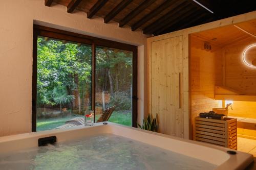 a large bath tub in a room with a window at Relais San Lorenzo in Abbadia San Salvatore