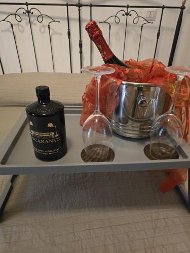 a shelf with a bottle of alcohol and glasses on it at Ancaranvs B&B in Bitonto