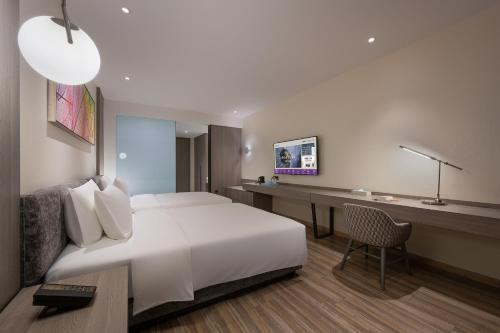a hotel room with a bed and a desk at Mercure Shanghai Hongqiao South in Shanghai