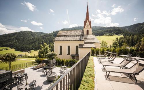 a church with chairs and a balcony with a church at Hotel Schölzhorn Superior in Racines