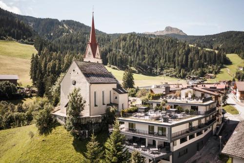 an aerial view of a building with a church at Hotel Schölzhorn Superior in Racines