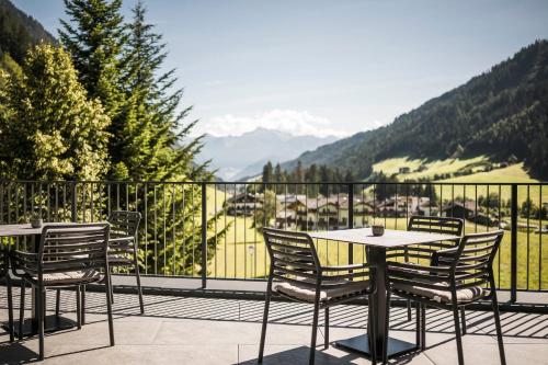 a table and chairs on a balcony with a view at Hotel Schölzhorn Superior in Racines