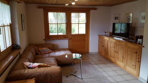a living room with a couch and a television at Ferienwohnung Gadenstatt in Davos