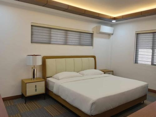 a bedroom with a large white bed and two windows at Aurora Villas and Cabin Resort in Clark