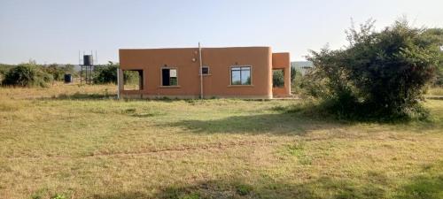 a small house in the middle of a field at Miliki Maasai Mara in Sekenani