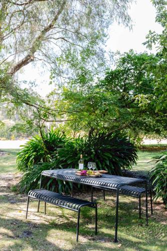 a picnic table in a park with two benches at The Farmhouse, elegance in the Margaret River coastal countryside in Rosa Brook