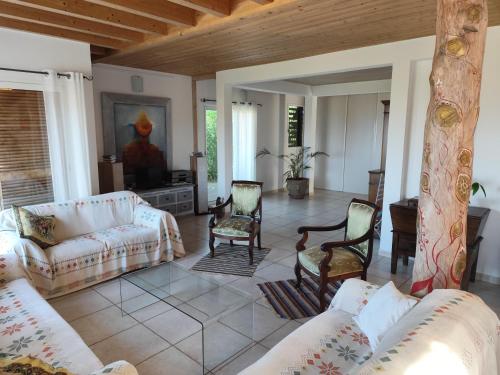 - un salon avec des canapés et des chaises dans l'établissement Villa avec piscine et belle vue mer proche des plages et commerces, à Porticcio