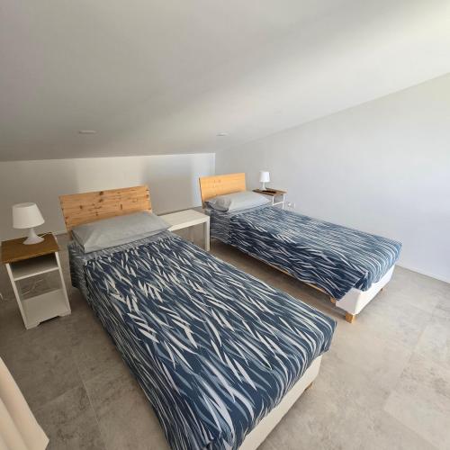 a bedroom with two beds and a night stand at I Secolari di Giulia in Avola