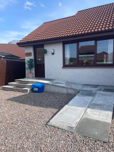 a house with a pathway leading to the front door at Riverside Retreat in Caol
