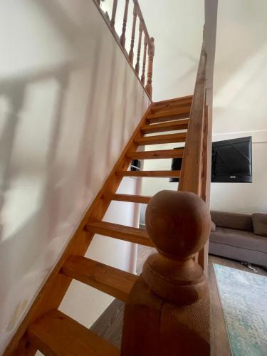 a wooden staircase in a living room with a couch at Алтын Балык in Toktogul