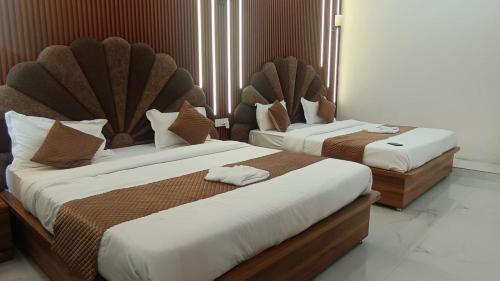 Hanumant Resort في دهرادون: سريرين في غرفة فندقية بها سريرين