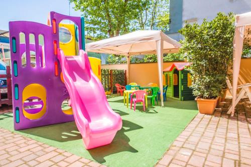 a playground with a slide and a play house at Hotel Giove dipendenza Hotel Fiamma in Cesenatico