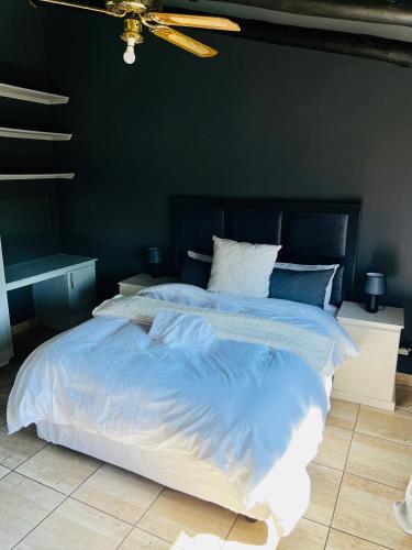 a bedroom with a large bed with blue walls at 13 Orion Aparment in Polokwane