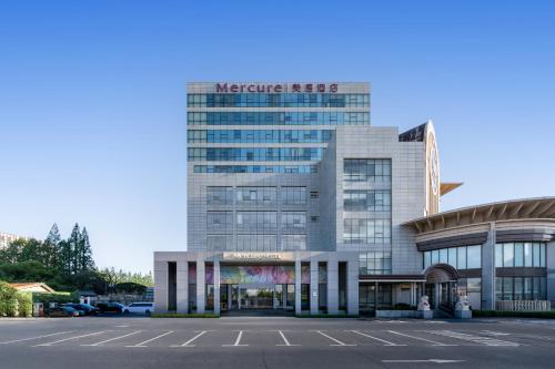 a large building with a parking lot in front of it at Mercure Shanghai Hongqiao South in Shanghai