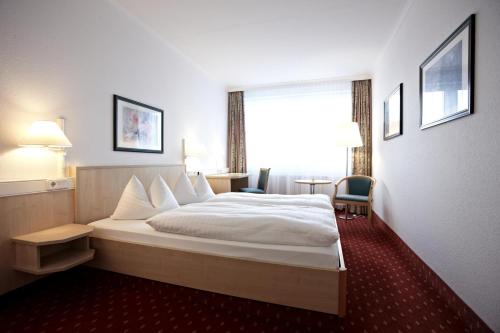 a hotel room with a bed and a window at IntercityHotel Schwerin in Schwerin