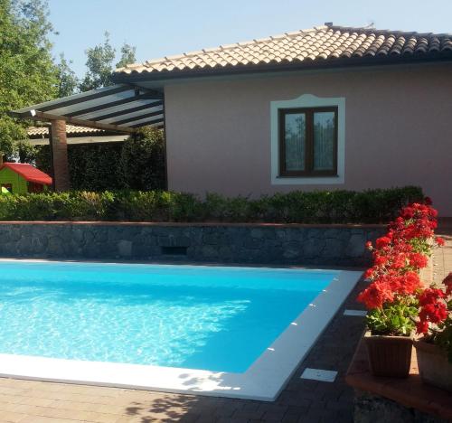 a swimming pool in front of a house at Poggiofelice B&B in Zafferana Etnea