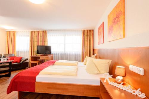 a hotel room with a bed and a living room at Familien- und Wellnesshotel "Viktoria" in Oberstdorf