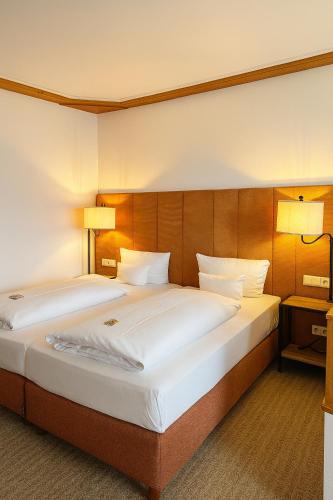 two beds in a hotel room with two lamps at Parkhotel an der Therme in Bad Krozingen