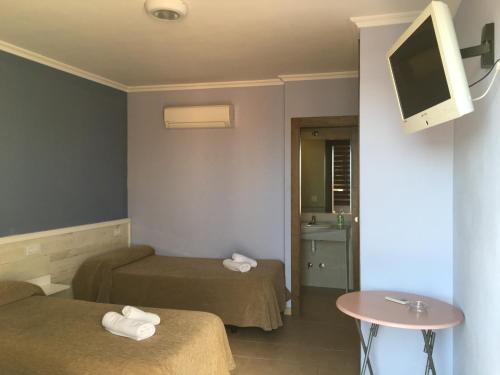 Cette chambre comprend 2 lits et une télévision. dans l'établissement Hostal Tarik, à Tarifa
