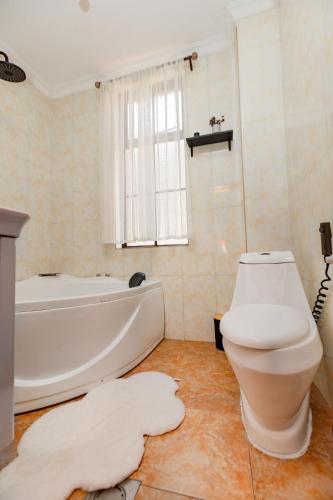 a bathroom with a white tub and a toilet at kigali Pillar House inn in Kigali