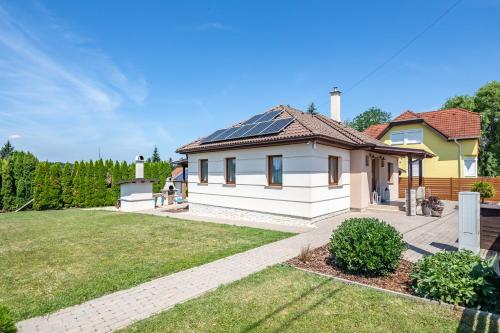 a house with solar panels on the roof at Borostyán Tó Vendégház in Zalalövő