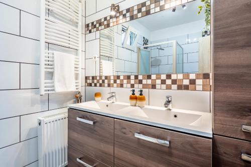 a bathroom with a sink and a mirror at Borostyán Tó Vendégház in Zalalövő