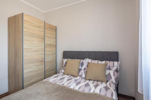 a bedroom with a bed with a wooden headboard at Borostyán Tó Vendégház in Zalalövő