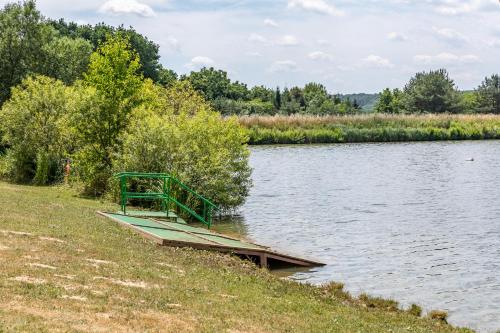 a small dock on the side of a lake at Borostyán Tó Vendégház in Zalalövő