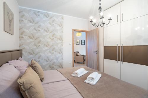a bedroom with a bed with two white towels on it at Borostyán Tó Vendégház in Zalalövő