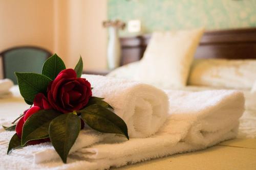 a towel with a rose on top of a bed at Hotel Ristorante Tre Stelle in Montepulciano