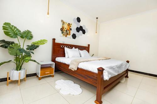 a bedroom with a bed and a potted plant at kigali Pillar House inn in Kigali