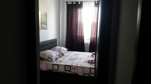 a bedroom with a bed with a window and a mirror at Apartament la mare Mamaia Nord in Mamaia Nord