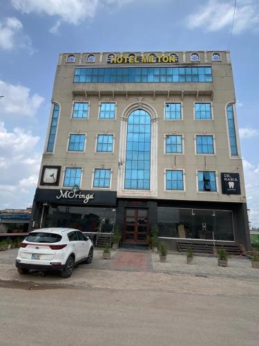 a white car parked in front of a building at Hotel Milton islamabad in Islamabad