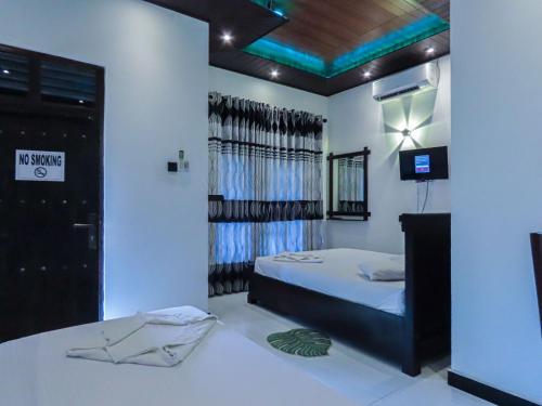 a bedroom with a bed and a television in it at Yala Zafiro in Kataragama
