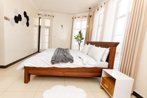 a bedroom with a bed with white sheets and pillows at kigali Pillar House inn in Kigali