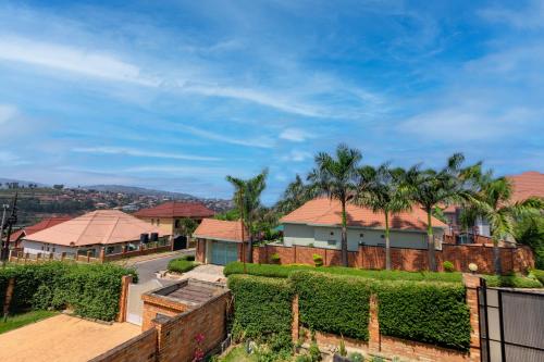 a house with a fence and palm trees at kigali Pillar House inn in Kigali
