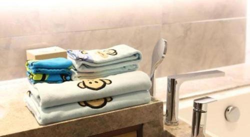 a pile of towels sitting on a counter in a bathroom at Empark Grand Hotel Fuzhou in Fuzhou