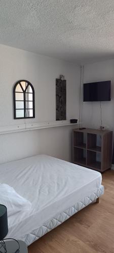 une chambre blanche avec un lit et une fenêtre dans l'établissement Studio Centre port Cap4, au Cap d'Agde