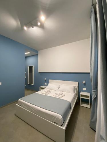 a bedroom with a bed in a blue room at L'Altalena Guest House in Lido Di Fondi