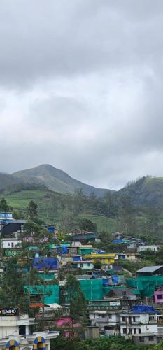 a group of buildings with mountains in the background at The Green Regency Annexe in Munnar