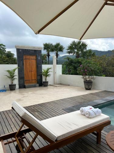 a patio with a pool and a table and an umbrella at Umah tumbu villa, private villa in Seraya