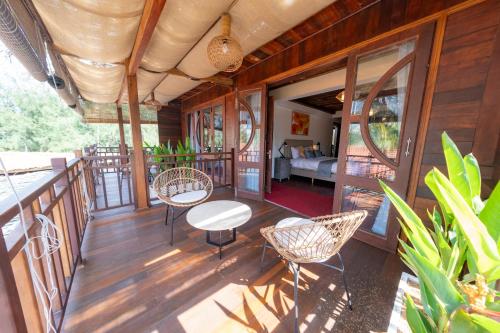 a porch of a house with chairs and a table at Hoianbang Beach Front Villa and Restaurant in An Bang