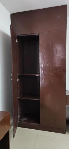 a brown cabinet with a empty shelf in a room at The Green Regency Annexe in Munnar