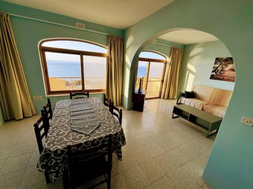 a dining room with a table and a view of the ocean at SeaView Sunset Gozo in Marsalforn